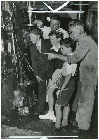 Chief officer George Todd, right, and his asistant Bob Luther explain the engine to John Rae, Jim Swan and James Wilton, on the ocean cruise to Broken Bay, South Steyne, December 1953 - Australian