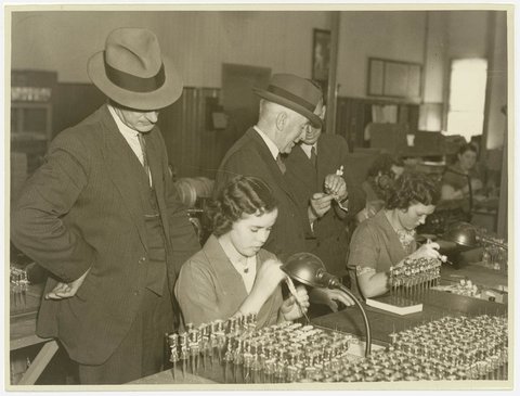 Executives watch women AWA factory workers making radio valves, 1936, by Sam Hood