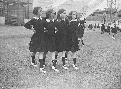 Group of four young schoolgirls singing as they dance round the maypole , 1935 - Sam Hood