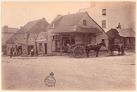 Weatherboard buildings, Market Street, at the corner of Clarence Street, Sydney, (Dec 1875) - by unknown photographer
