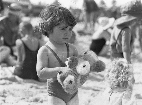 Small girl with toy koala on the sand, Bondi Beach, c.1932 - by Sam Hood, c. 1932