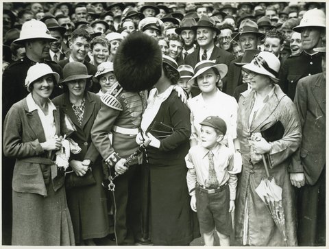 A member of the Band of His Majesty's Grenadier Guards kissing a person in crowd in Martin Place, Sydney after a ceremony at the Cenotaph, 8 November 1934