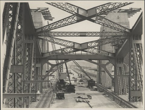 Cranes and workmen on the central roadway of the Sydney Harbour Bridge, 1932