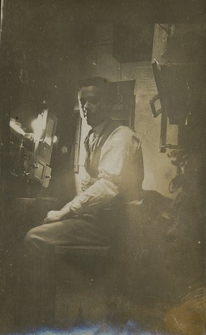 Stan Allan seated in projection room at Haymarket Theatre, Sydney, 1920 - 1929, 1920s