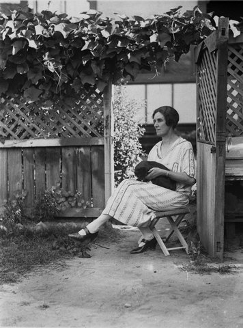 Unidentified women sitting on stool in garden with black cat, 1930s, Sam Hood, c. 1930