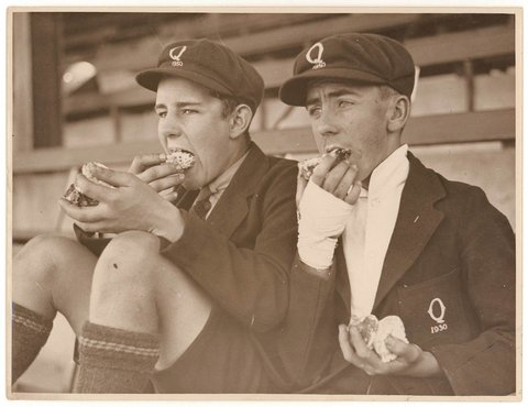 Schoolboy fans eat cake, c. 1930, by Sam Hood
