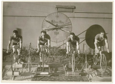 Four cyclists on speed bicycles on rollers time trials to promote Malvern Star- from left, Lennie Rogers, Bill Moritz, - ?, - ?), by Sam hood, 1925–40