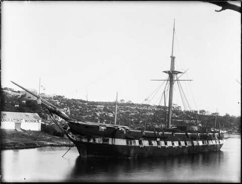 Single masted passenger vessel near shore, 1898