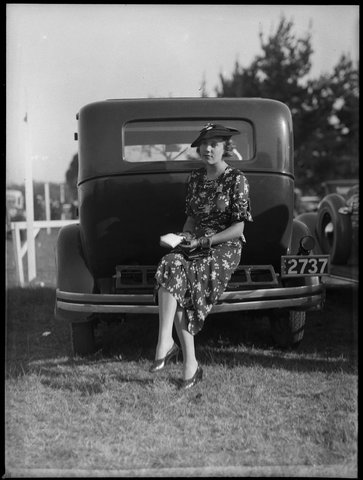 Woman sitting on bumper bar of a car at Warwick Farm racecourse from The Powerhouse Museum, 1930–50