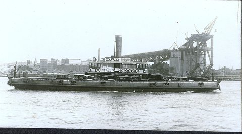 Sydney vehicular ferry KOOROONGABBA passing Sydney Harbour Bridge under construction late 1920s
